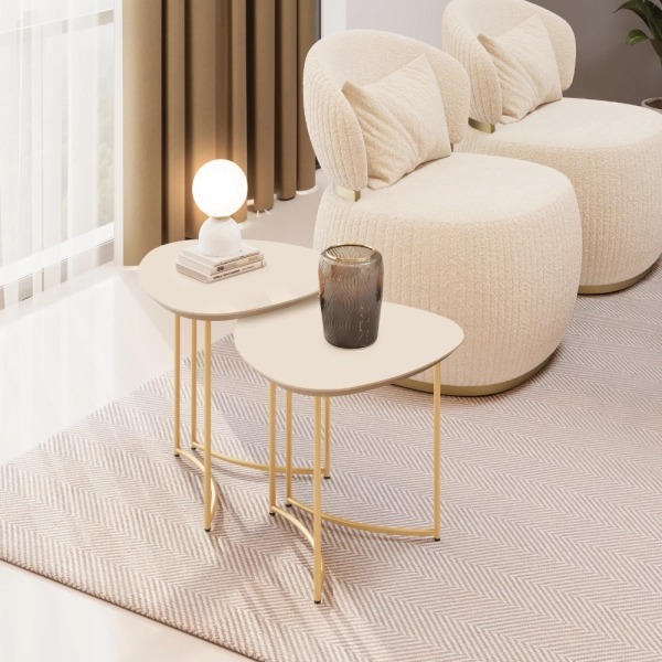 Juego de mesas laterales Pétala off white al lado de un sillón
