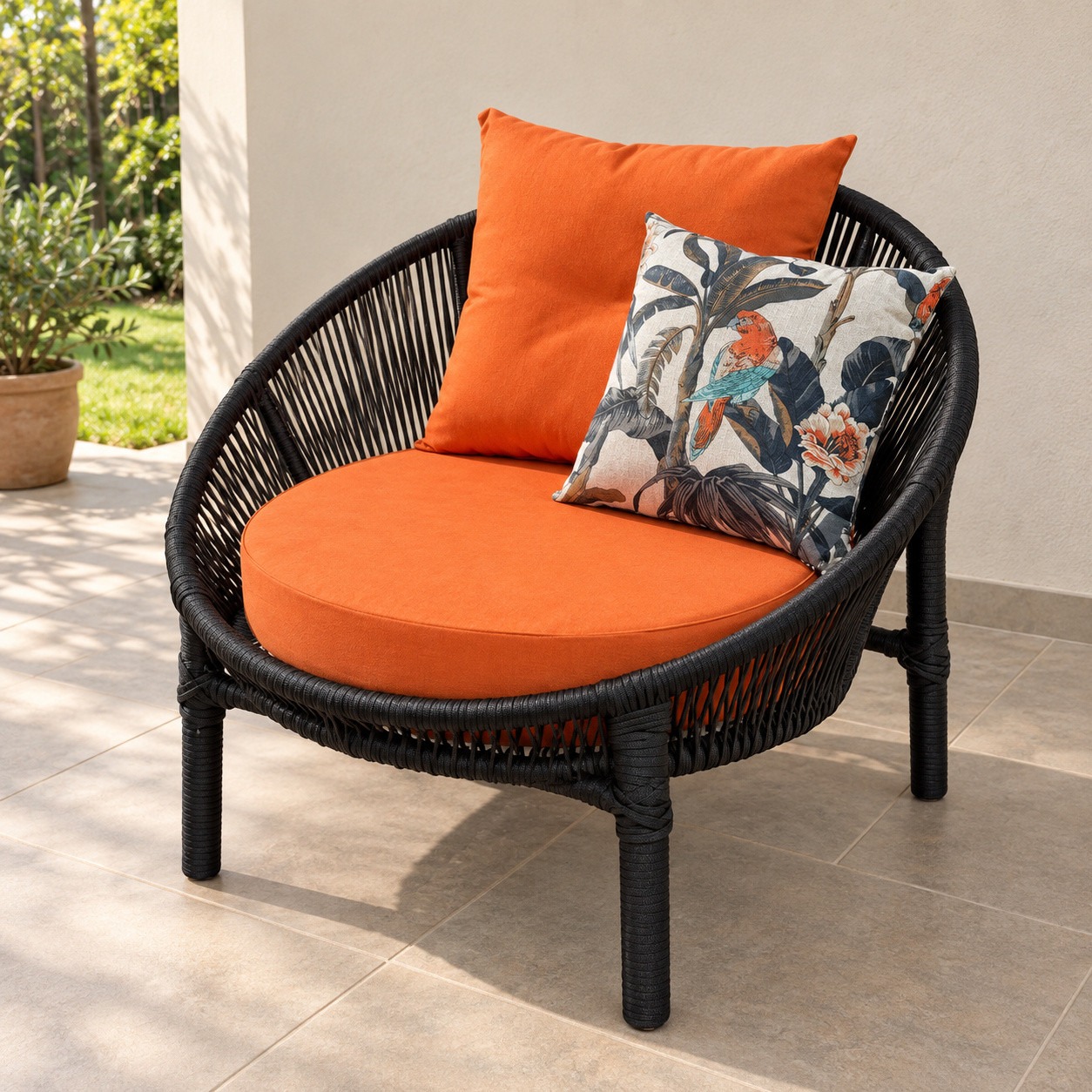 Sillón de cuerda náutica negra con almohadones naranja del juego exterior Caribe